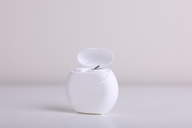 Photo of Container with dental floss on white background