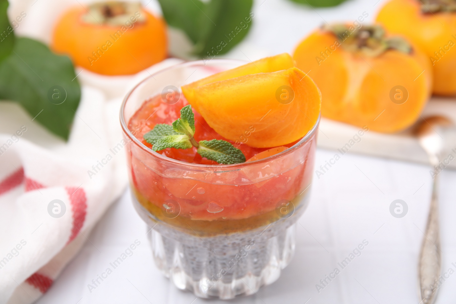 Photo of Delicious dessert with persimmon and chia seeds on table