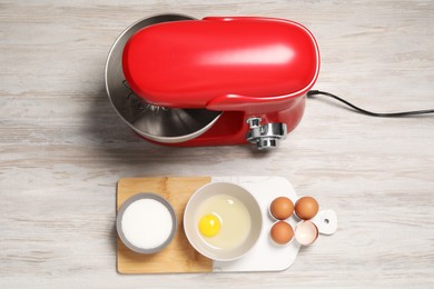 Photo of Modern red stand mixer and different ingredients on white wooden table, flat lay