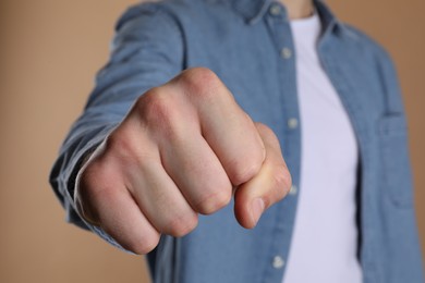 Man showing fist with space for tattoo on beige background, selective focus