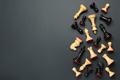 Photo of Many different chess pieces on black background, flat lay. Space for text