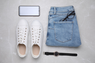 Flat lay composition with stylish clothes and accessories on grey marble table