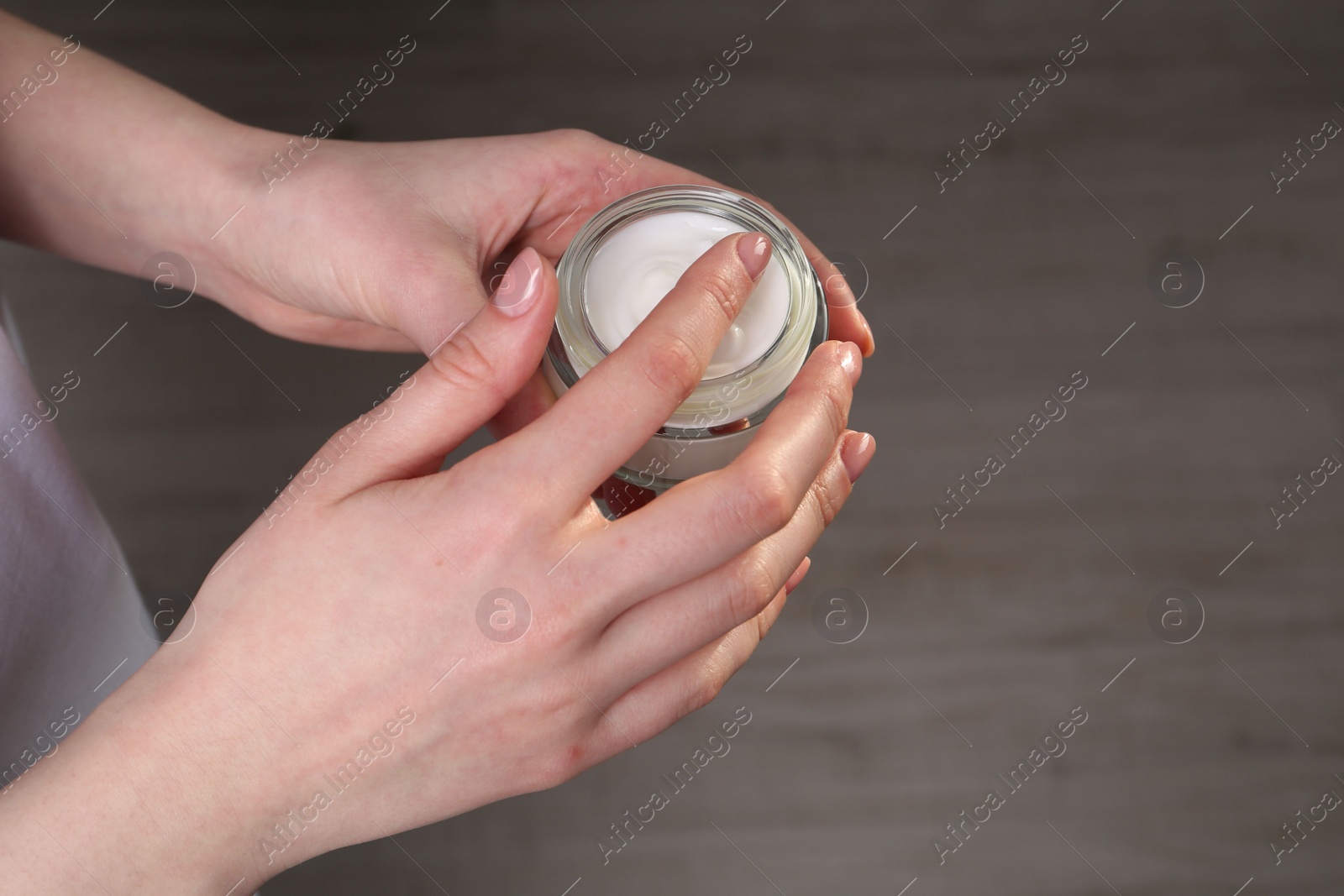 Photo of Woman applying hand cream indoors, above view