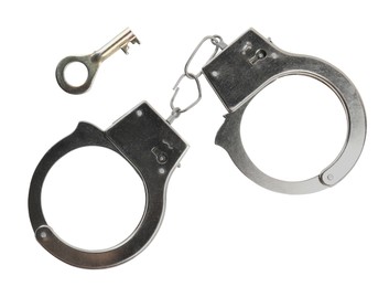 Photo of Classic chain handcuffs with key on white background, top view