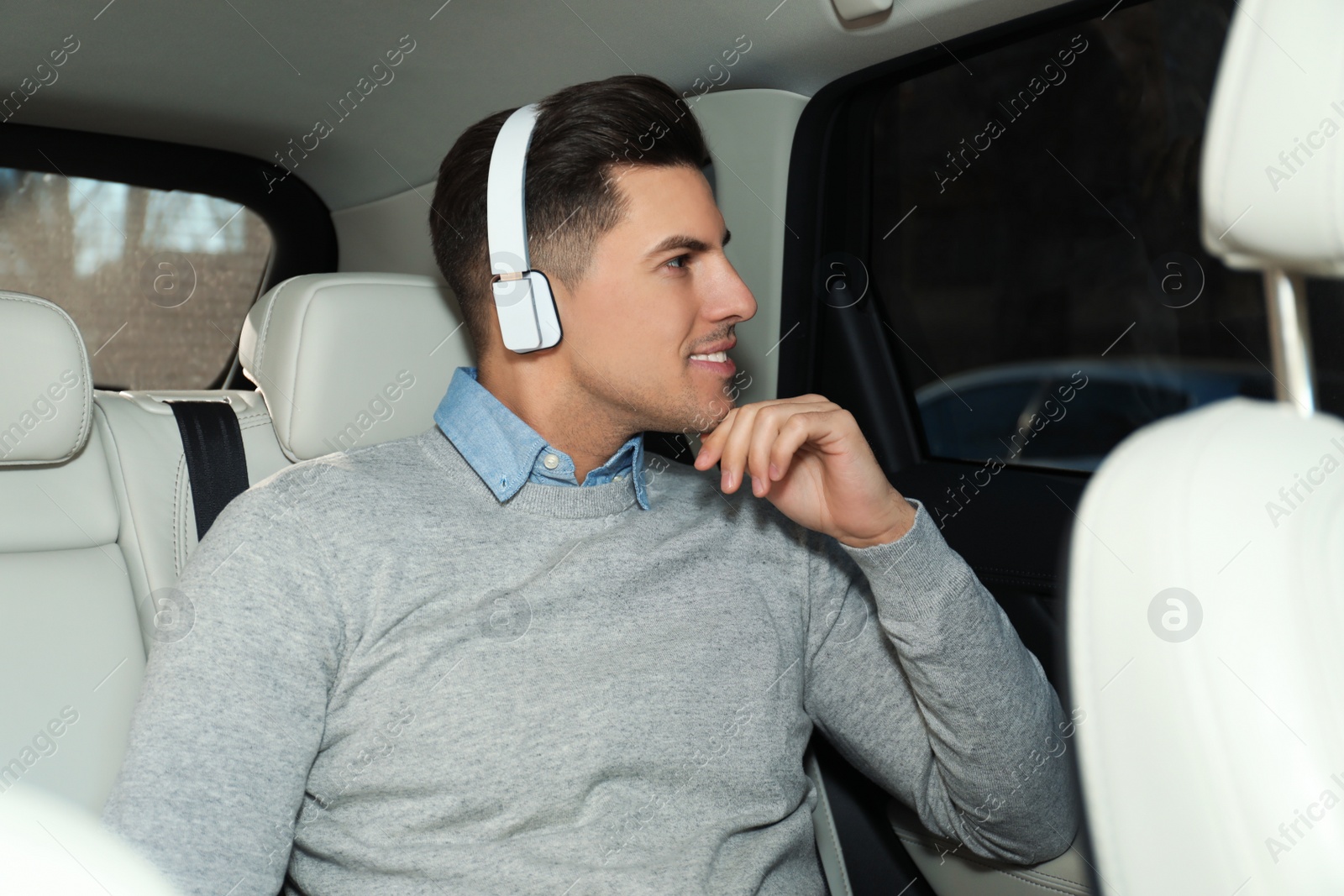 Photo of Handsome man listening to audiobook in car