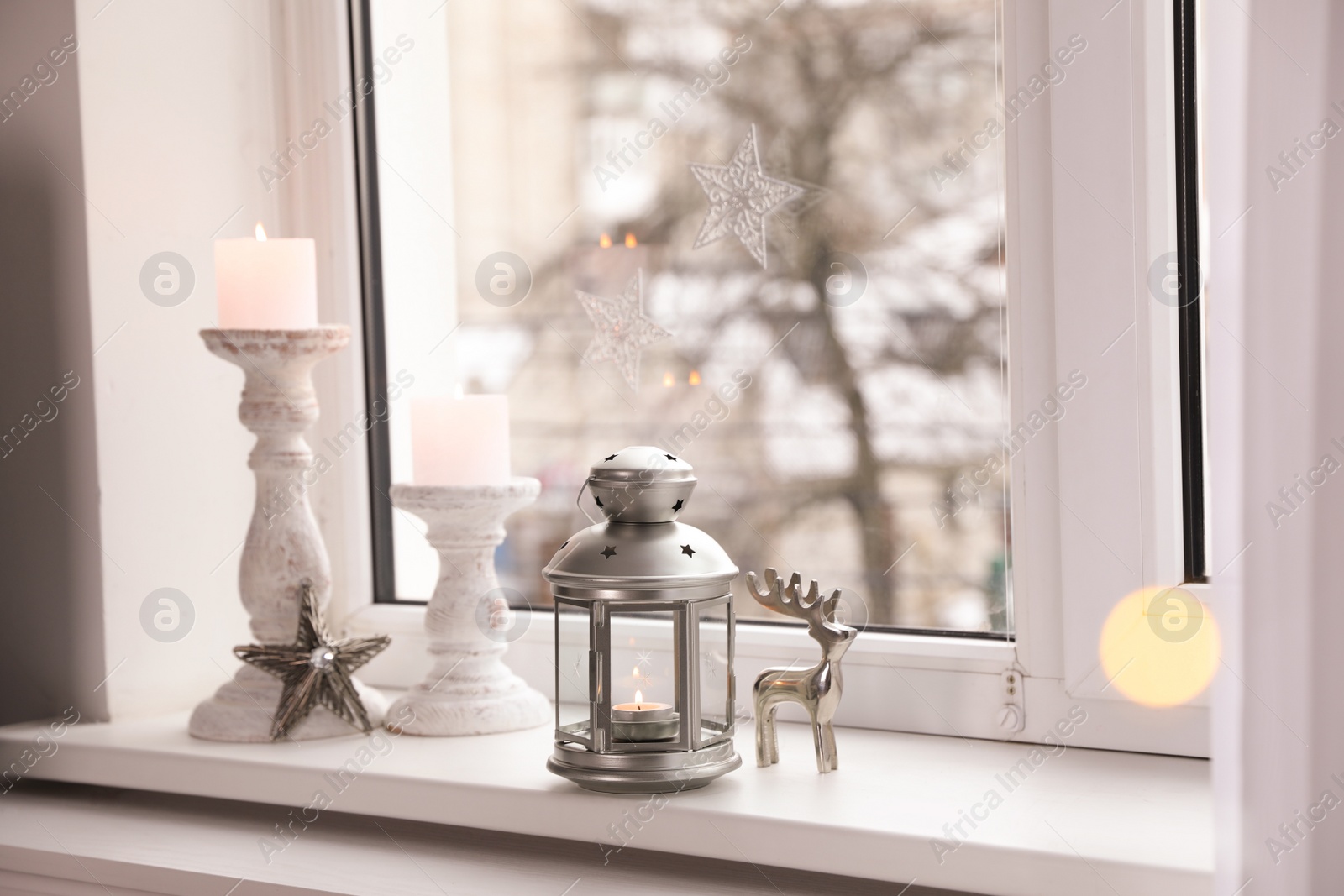 Photo of Decorative Christmas lantern and candles on windowsill