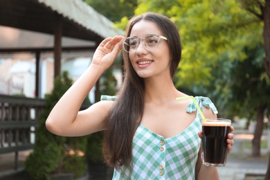 Young woman with cold kvass outdoors. Traditional Russian summer drink