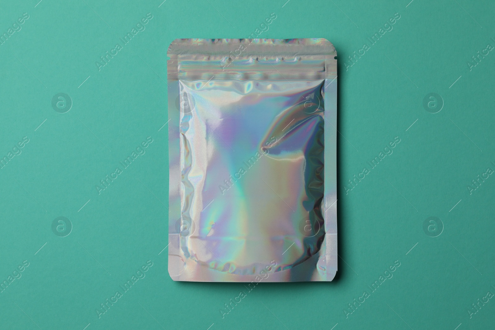 Photo of Blank foil package on turquoise background, top view