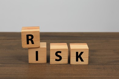 Photo of Cubes with word Risk on wooden table