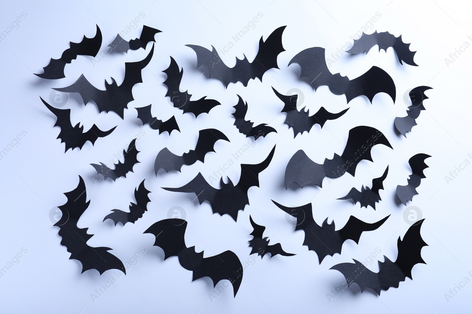 Photo of Many black paper bats on white background, flat lay. Halloween decor