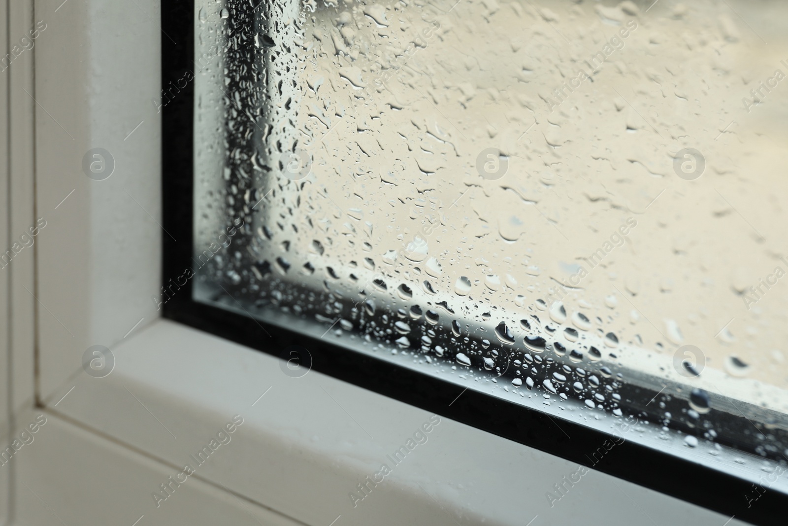 Photo of Window glass with drops of condensate indoors, closeup