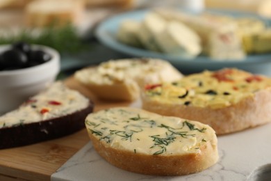 Photo of Different types of tasty butter and bread on table, closeup