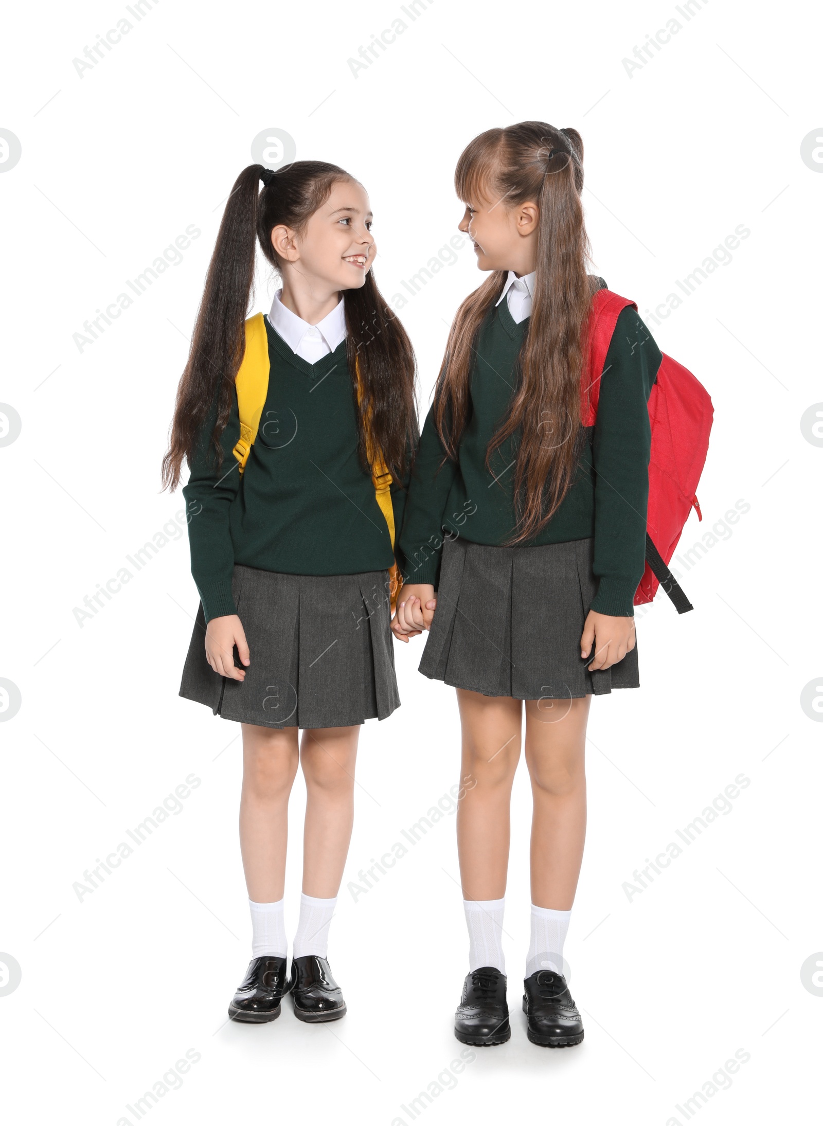 Photo of Little girls in stylish school uniform on white background