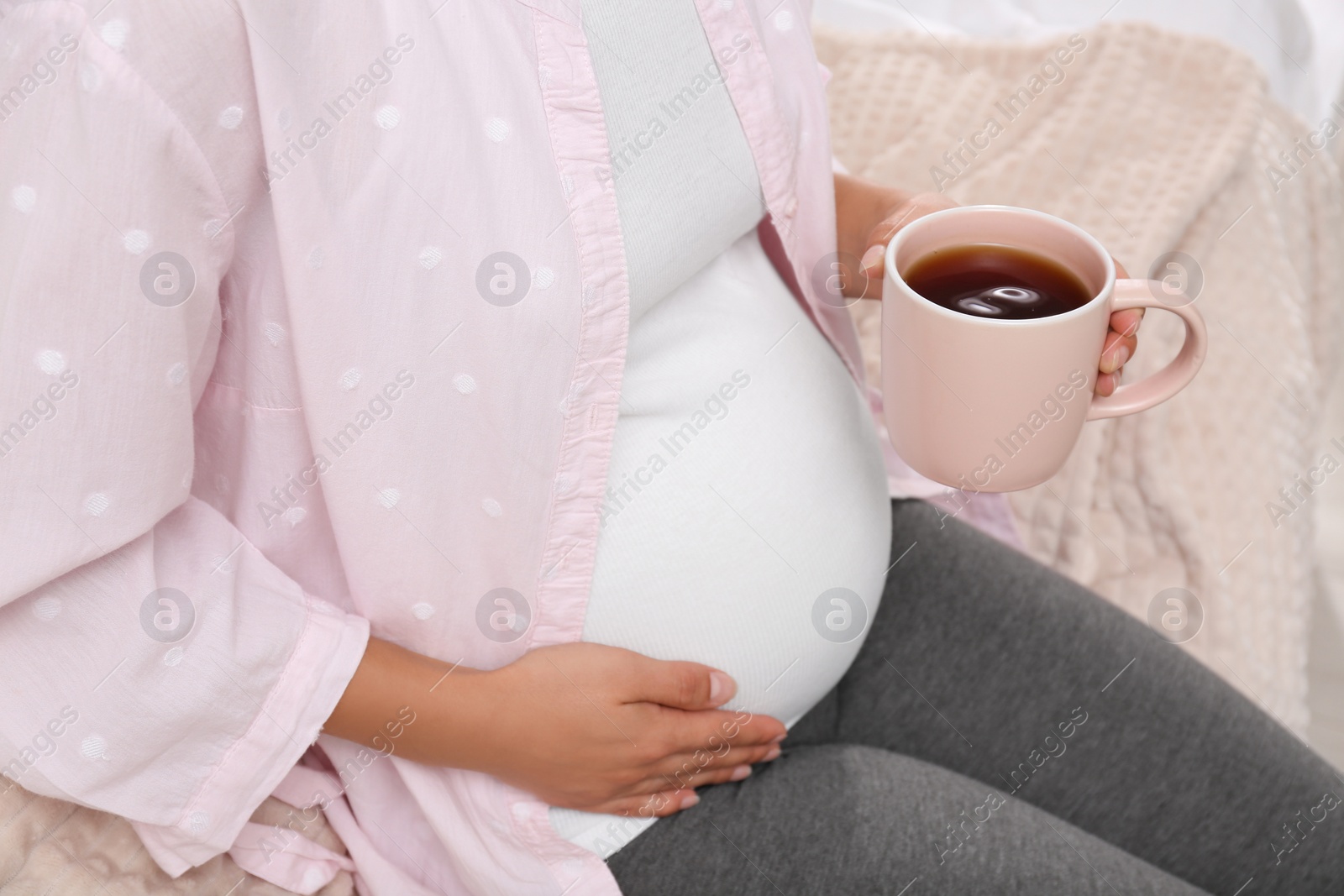 Photo of Pregnant woman drinking tea at home, closeup