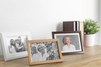 Photo of Framed photos on cabinet near white wall
