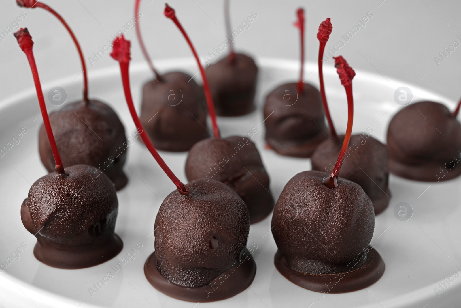 Photo of Chocolate dipped cherries on plate, closeup