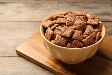 Photo of Sweet crispy corn pads in bowl on wooden table