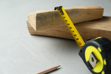 Photo of Tape measure on light grey table, closeup. Space for text