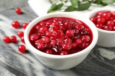 Fresh cranberry sauce in white bowl on marble board