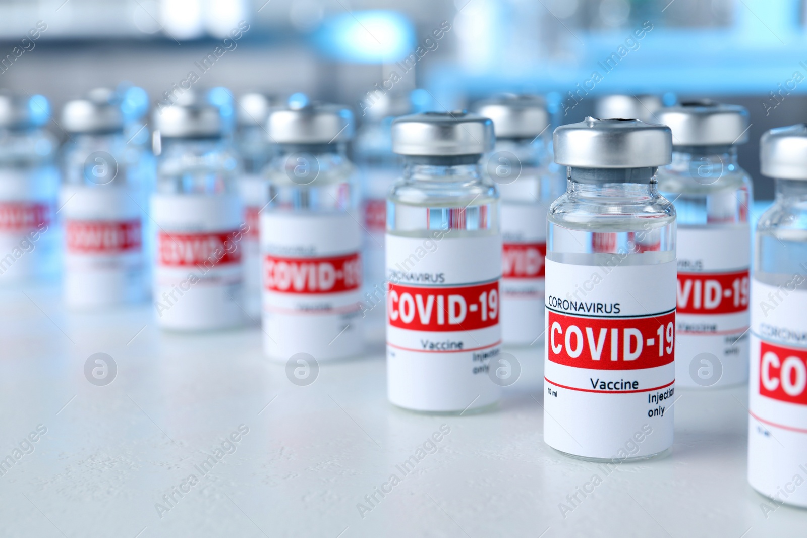 Photo of Glass vials with COVID-19 vaccine on light table