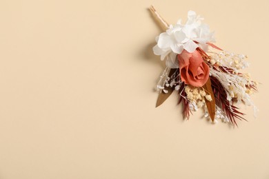 Photo of Stylish boutonniere on beige background, top view. Space for text