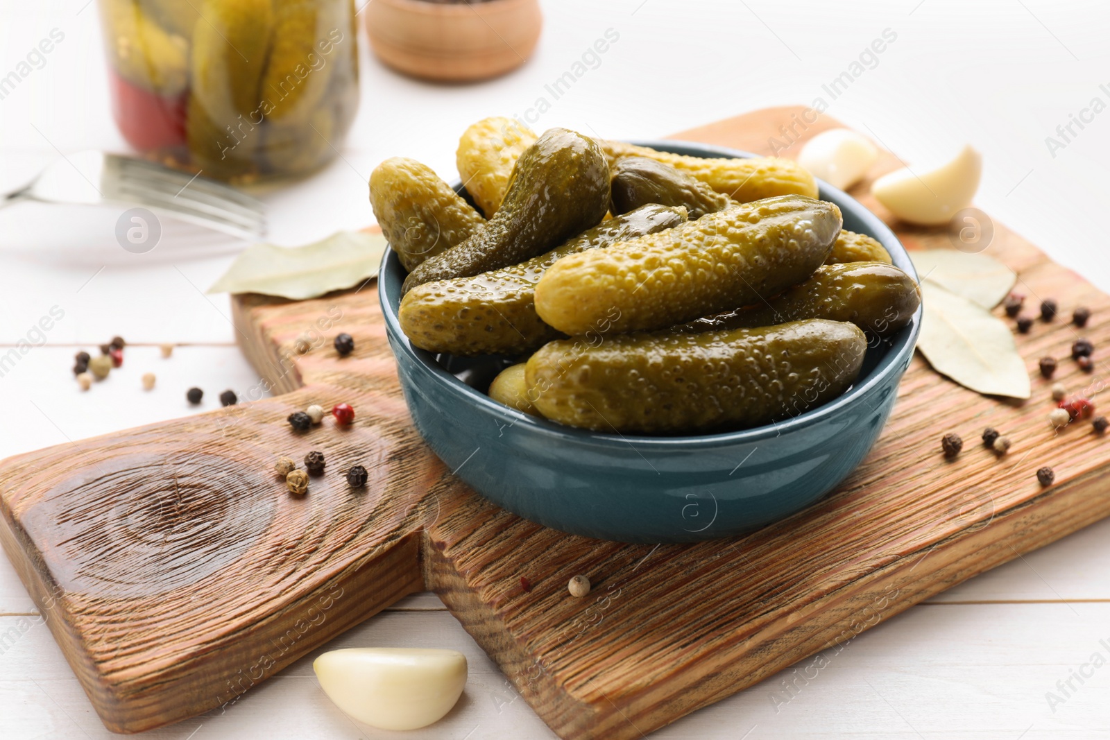 Photo of Tasty pickled cucumbers and spices on white wooden table