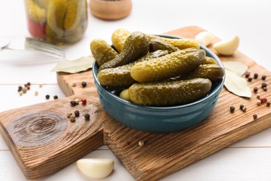 Photo of Tasty pickled cucumbers and spices on white wooden table