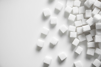 Photo of Refined sugar cubes on light background, top view