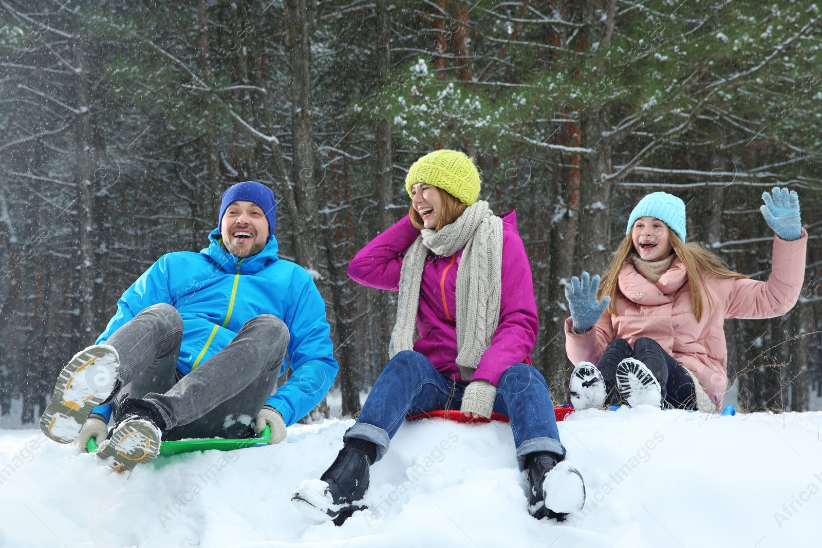 Photo of Happy family sledding in forest on snow day