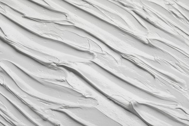 Photo of Strokes of white oil paint as background, closeup
