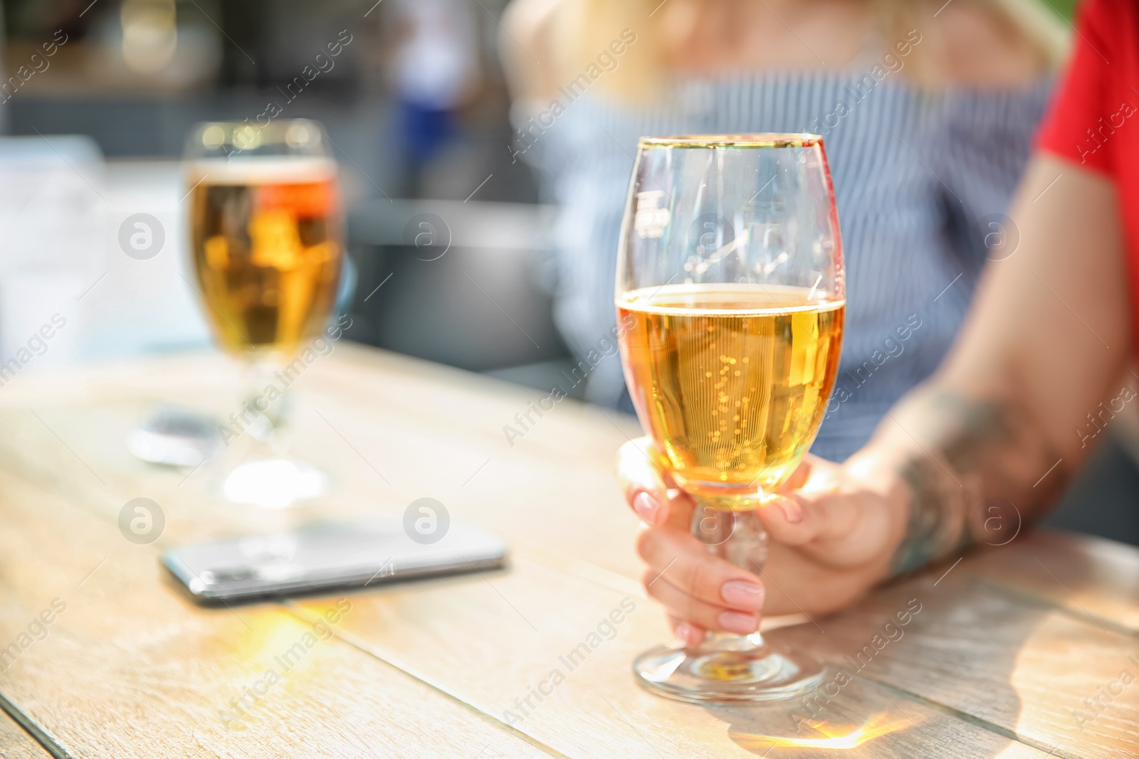 Photo of Young women with glasses of cold beer at table