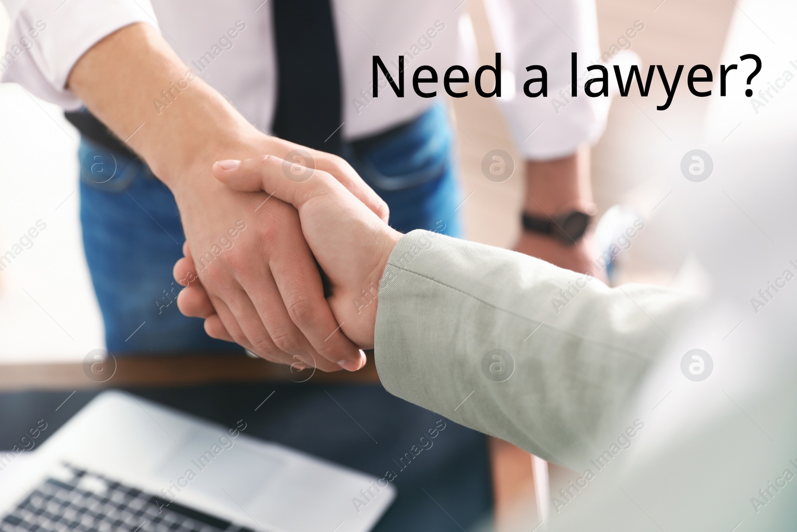 Image of Business partners shaking hands at table in office, closeup. Need a lawyer?