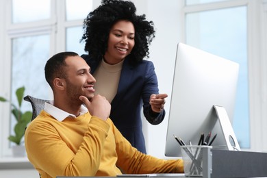 Young colleagues working together at table in office