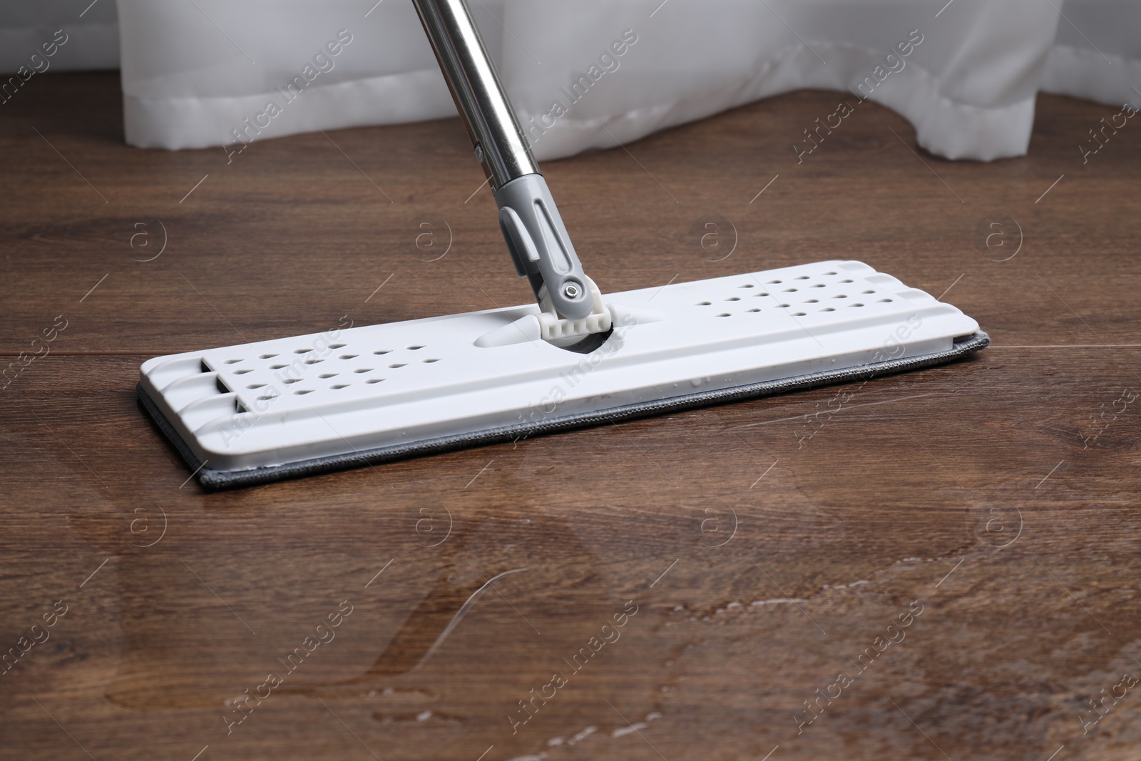 Photo of Cleaning dirty parquet floor with mop, closeup