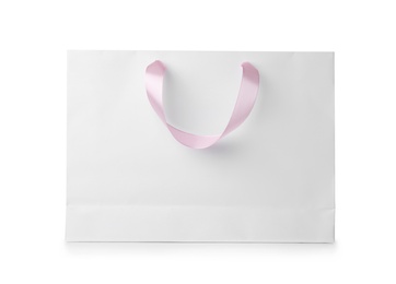 Photo of Paper shopping bag with ribbon handles on white background. Mockup for design