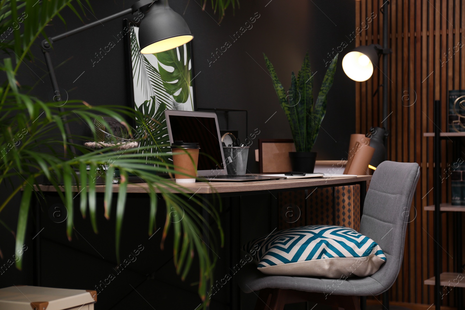 Photo of Comfortable workplace with modern laptop on desk. Home office