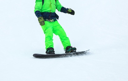 Photo of Snowboarder on slope at resort, closeup. Winter vacation