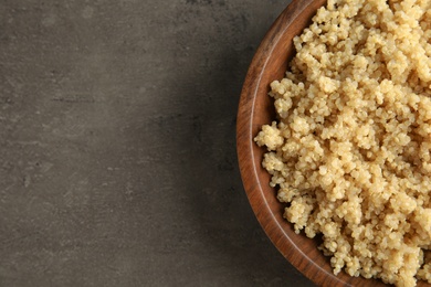 Cooked delicious quinoa in wooden bowl on table, top view. Space for text