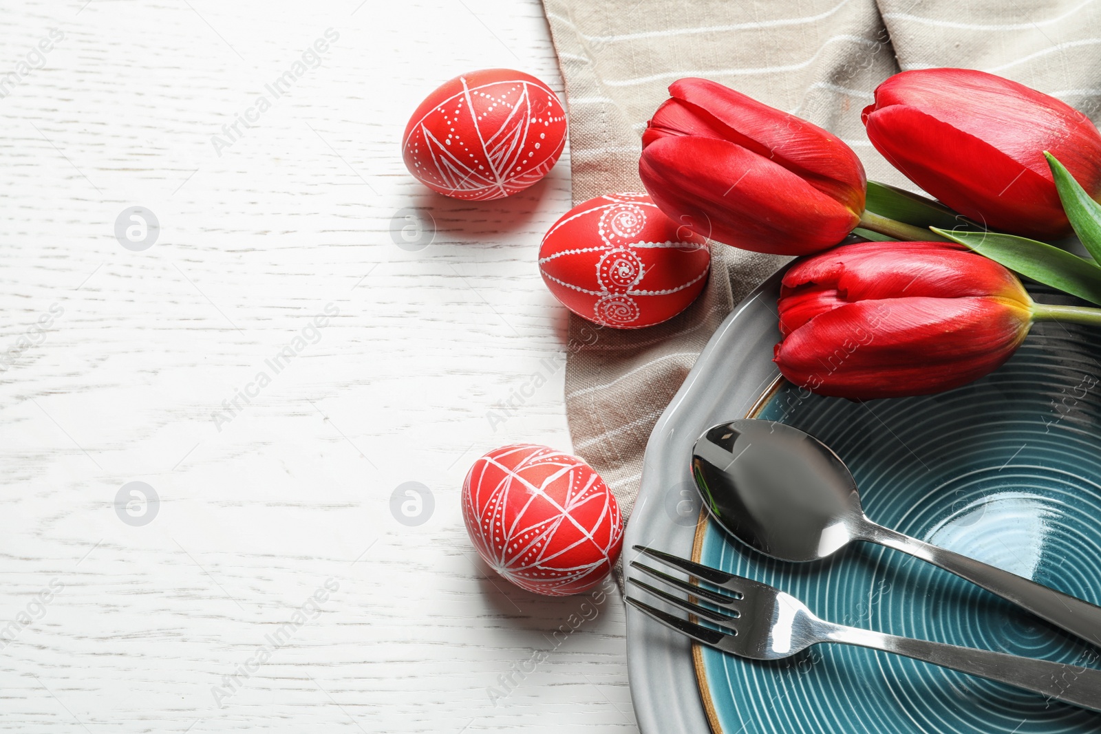 Photo of Festive Easter table setting with flowers on wooden background, top view. Space for text