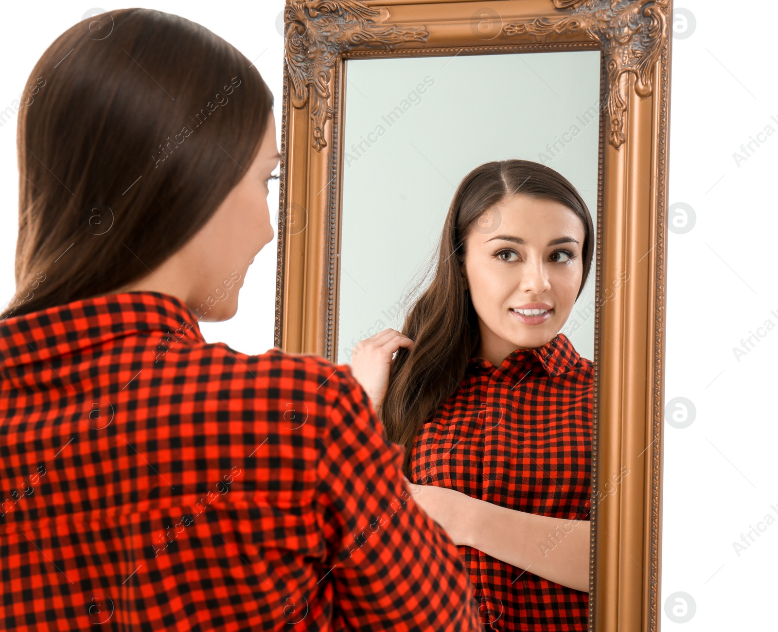 Photo of Young woman looking at her reflection in mirror on white background