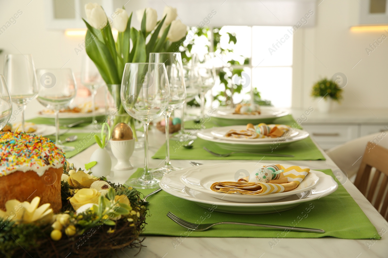 Photo of Festive Easter table setting with floral decor in kitchen