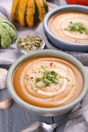 Photo of Delicious pumpkin soup served on gray wooden table