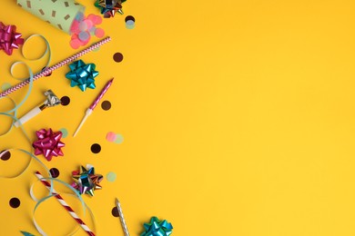 Photo of Party popper with confetti, blower and festive decor on orange background, flat lay. Space for text