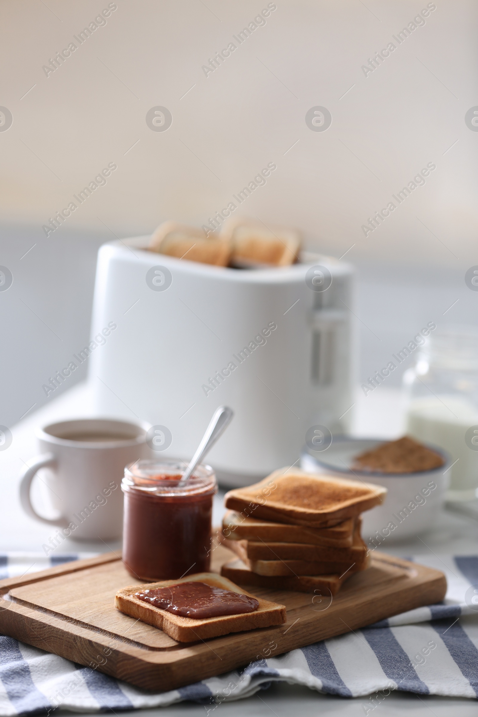 Photo of Modern toaster and delicious breakfast on table in kitchen