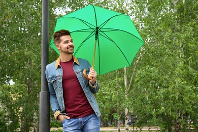 Photo of Man with umbrella outdoors on rainy day