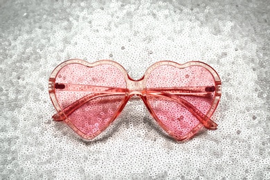Photo of Pink heart shaped sunglasses on bright background
