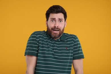 Portrait of surprised man on yellow background