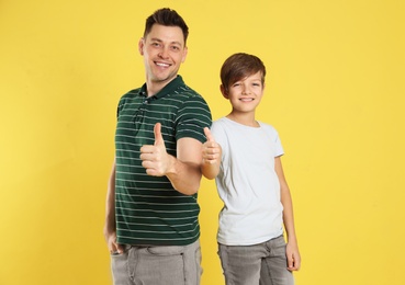 Portrait of dad and his son on color background