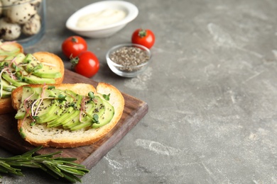 Tasty toasts with avocado, sprouts and chia seeds on wooden board. Space for text