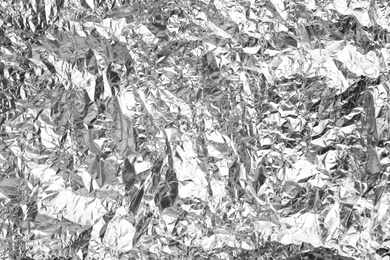 Photo of Crumpled silver foil as background, closeup view